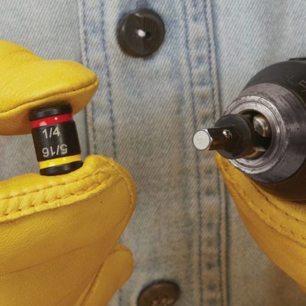 Man holding removable and reversible hex of MSHC off of a drill