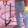 Radiant heating worker using a Malco FBSN tool to staple pex to foam board