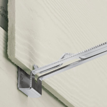Close of a fiber cement siding board being held up with a Malco FCG2 tool