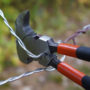 Malco's FCP1 tool being used to cut a piece of barbed fencing wire