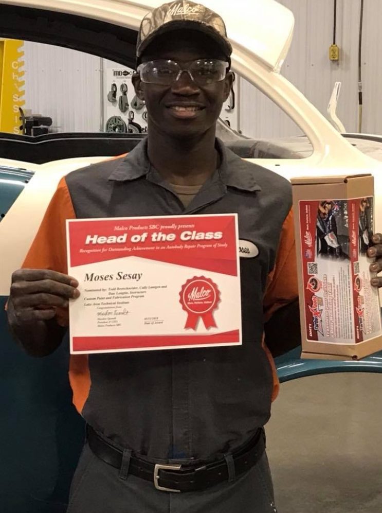 Student holding Head Of Class certificate