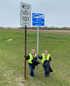 Two women on the side of the highway doing highway cleanup.