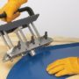 Malco's ER3 Edge Rolling Tool forming a corner of blue painted metal roofing