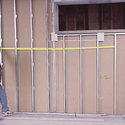 Man using measuring tap to show how well the magnetic tape measures works