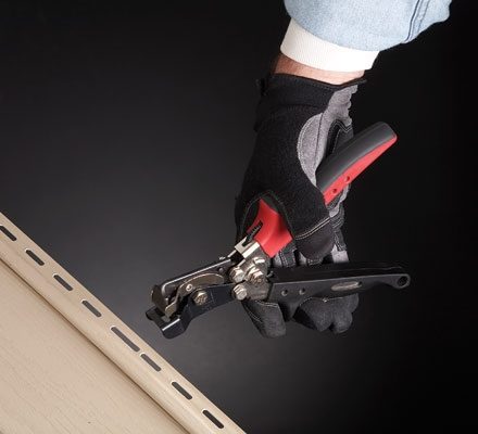 Person using Malco's Nail Hole Punch on a section of vinyl siding