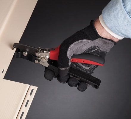 Person using Malco's Snap Lock Punch to create tabs in Vinyl Siding